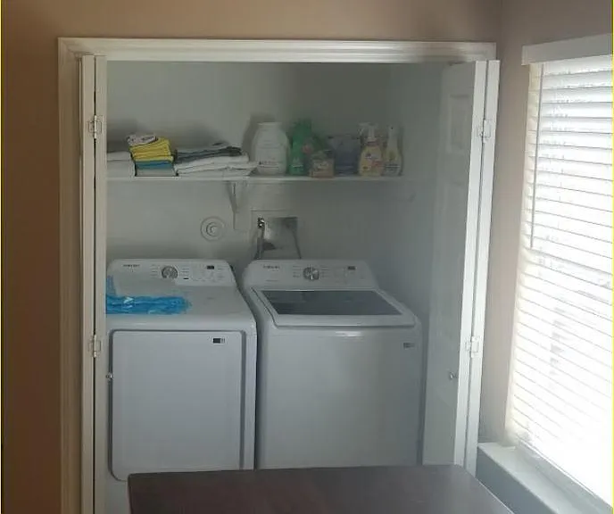 Laundry center with new appliances is convenient to dining (folding) table.