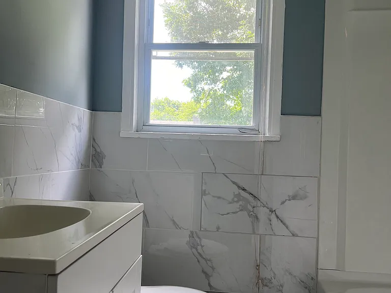Completely remodeled Bathroom with new vanity, bathtub with shower and porcelain tiles in floor and walls