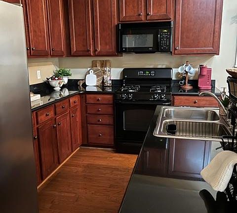 Kitchen with cherry cabinets and black granite countertops