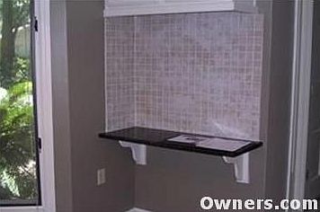 desk area (granite) in kitchen with storage above.