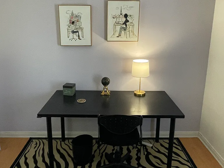 Private office space features comfy adjustable office chair, rug under feet, reference books, charging strip for multiple devices.