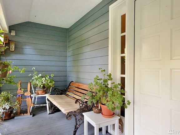 Cute Covered Country Porch Extends on the Other Side of Front Door