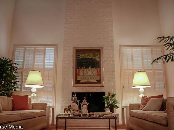 Beautiful gaslog fireplace flanked by big windows.