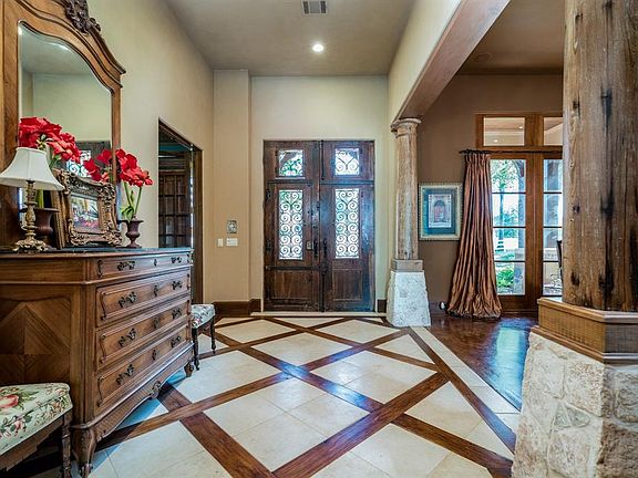 Step inside to an entry that is as unique as the doors you just walked through! A travertine tile floor is inlaid with wood beams from Houston's landmark restaurant, Shangai Red's, after its doors were forever closed. Also featured are antique column