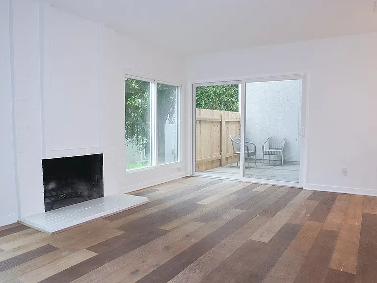 Living Room with hardwood floors and wood-burning fireplace.