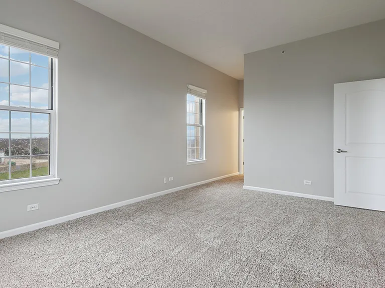 Spacious carpeted bedroom with natural light