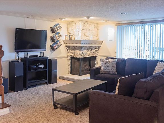 The lower level has tons of extra living space. This living room features a gas stone fireplace with custom millwork mantel, sli