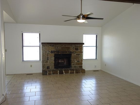 Lots of light in this vaulted living room with modern ceiling fan and easy to maintain tile floor.