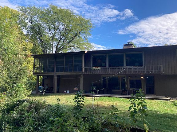 View of back of house see large picture windows a screened in porch for enjoying the fantastic scenery
