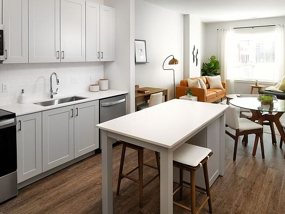 New West Phase - Finish Package III Kitchen with stainless steel appliances, white quartz countertops, grey cabinetry, and hard surface flooring throughout