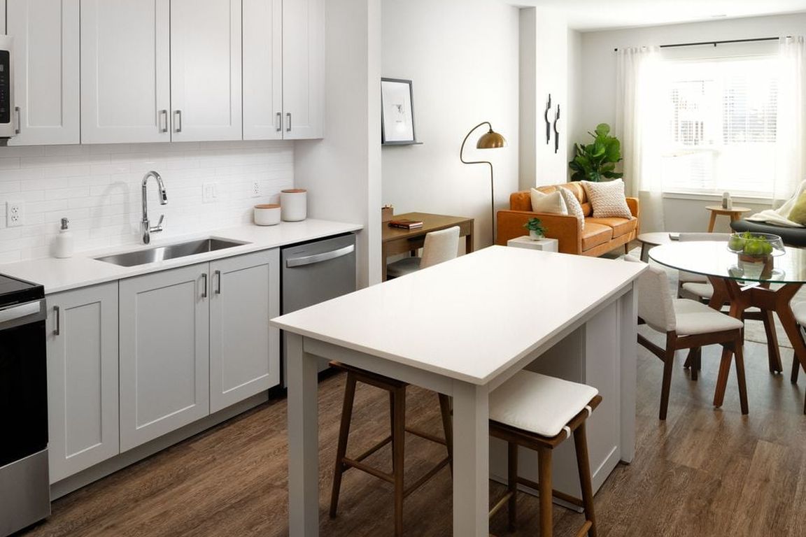 New West Phase - Finish Package III Kitchen with stainless steel appliances, white quartz countertops, grey cabinetry, and hard surface flooring throughout