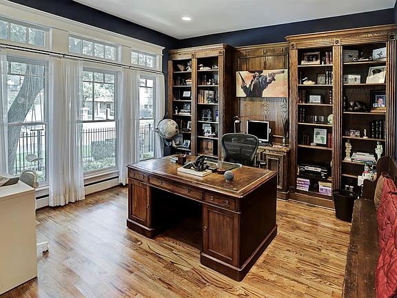 Large study with built in bookshelves and windows that look out to the front.