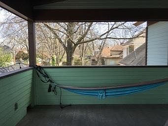 the upstairs covered porch is divine. ceiling fans, tin roof, small patio table, watch the seasons from the treetops.