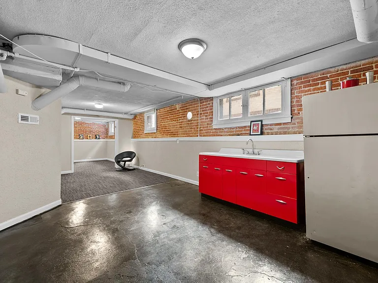 Kitchenette in basement. Stained concrete floors.