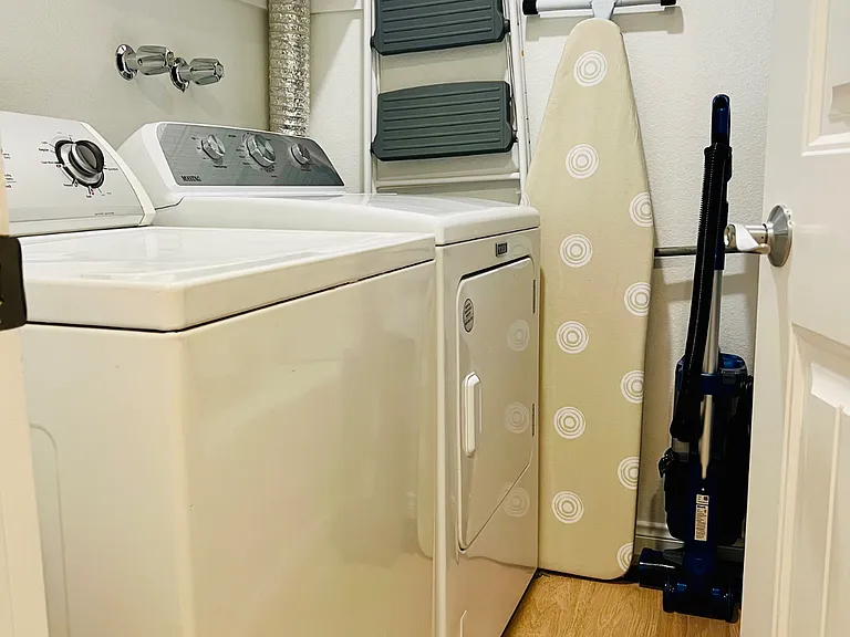 This room has the full sized washer dryer, storage shelves, ladder, and vacuum