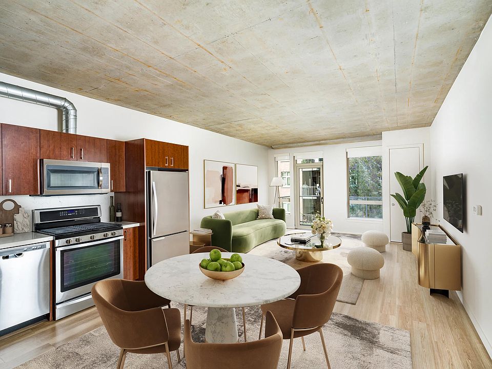 An open apartment home at Modera Pearl with concrete ceilings, warm wood flooring, and flexible living space that adapts easily to your style.