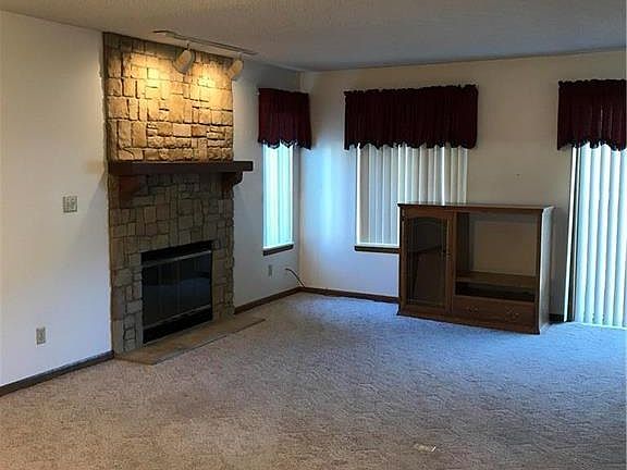 Living room is open and bright. Fireplace and newly cleaned carpeting.