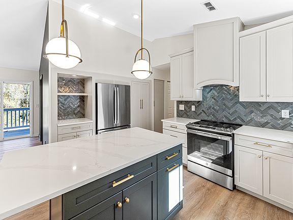 Beautifully updated main level kitchen with stainless steel appliances, coffee bar, and island with space for seating.