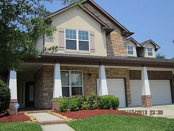 This home has a large covered porch that extends  over the garage doors.