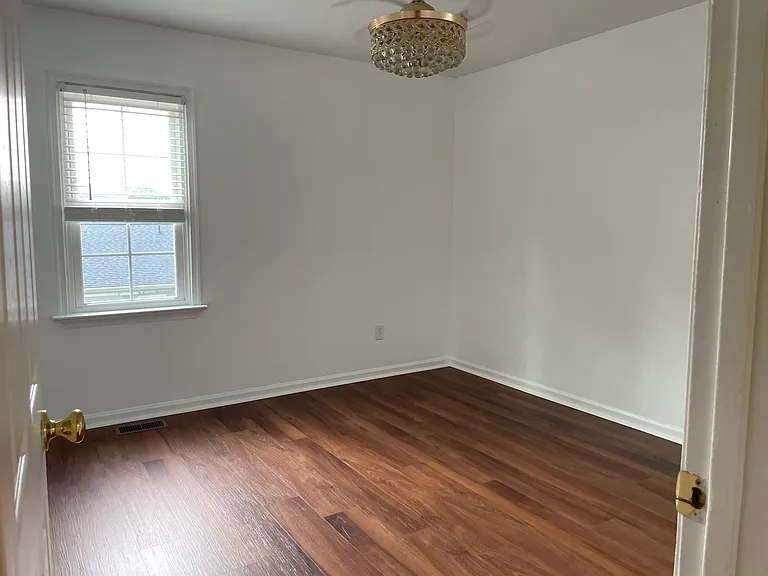 Bedroom 2 with crystal fixture, fresh paint and brand new luxury vinyl flooring.