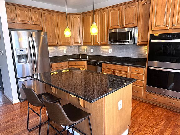 Granite island and countertops with undercounter lights; new backsplash; new fridge, stove, double-wall oven