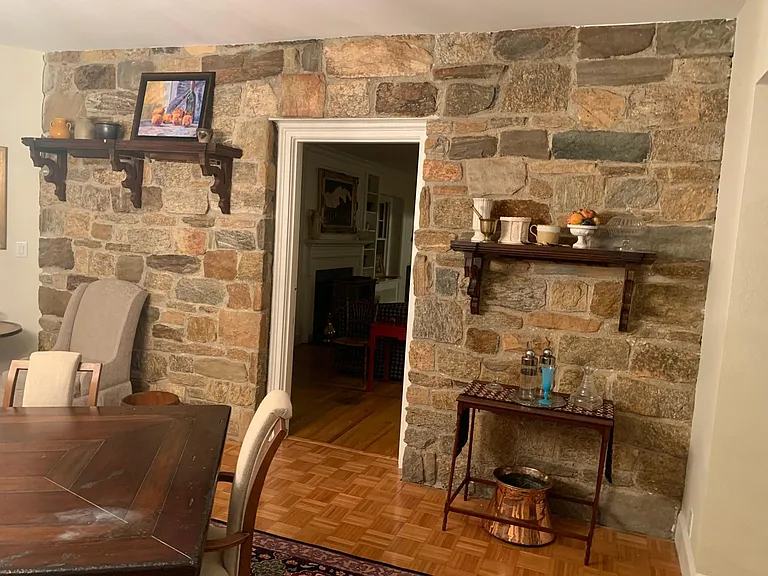 Dining room original stone wall to house leading into living room