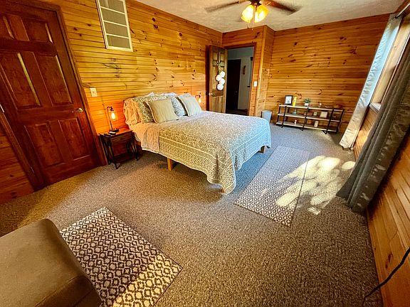 South facing bedroom has queen bed ceiling fan, armchair and ottoman, Roku TV, blackout curtains, built in drawers and a walk-in closet with a full length mirror.