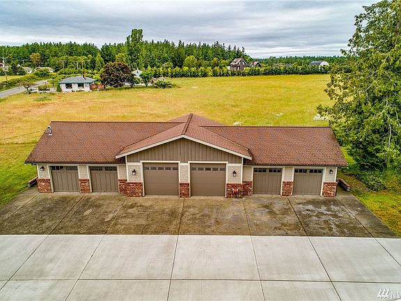 The heated, fully finished (insulated, sheet rocked, and painted) 2336 sq ft garage/shop building has six bays, the center two are 30x30' with 10' doors. There is a half bath in the right-most bay. The entry door is on the left of the building, and there is additional outdoor covered storage behind the building.