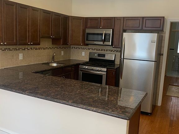 kitchen - granite countertops, bar overhang, stainless steel appliances including full size refrigerator, dishwasher, microwave and self cleaning gas range, garbage disposal and