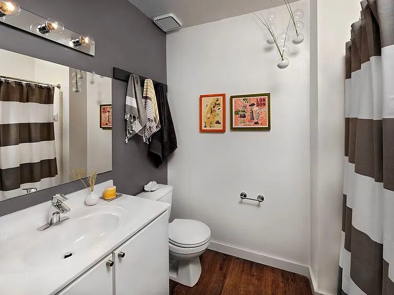 Classic Package bath with white cabinetry and vanity, grey accent wall and hard surface flooring