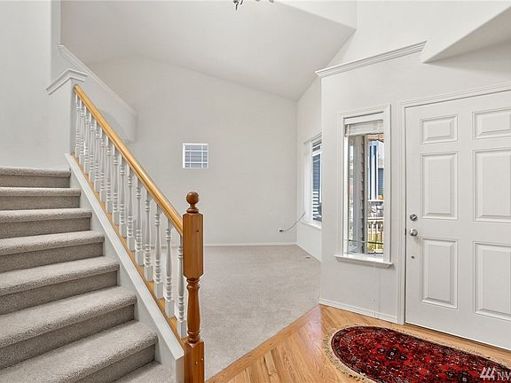 The entryway has cathedral ceilings and is bright with fresh paint, gleaming re-finished hardwood floors, and new carpet.