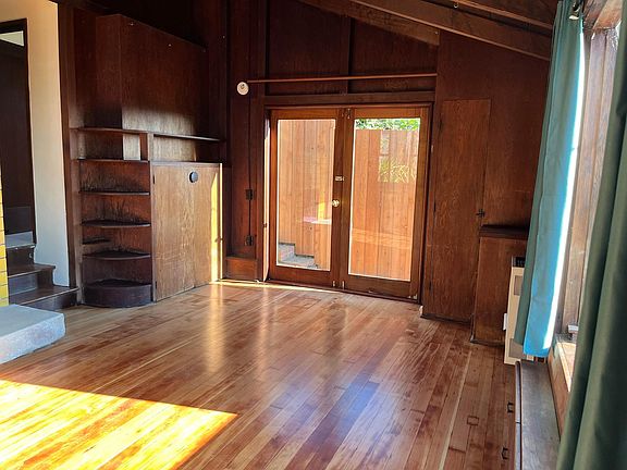 Main room and doors out to side yard and front deck.