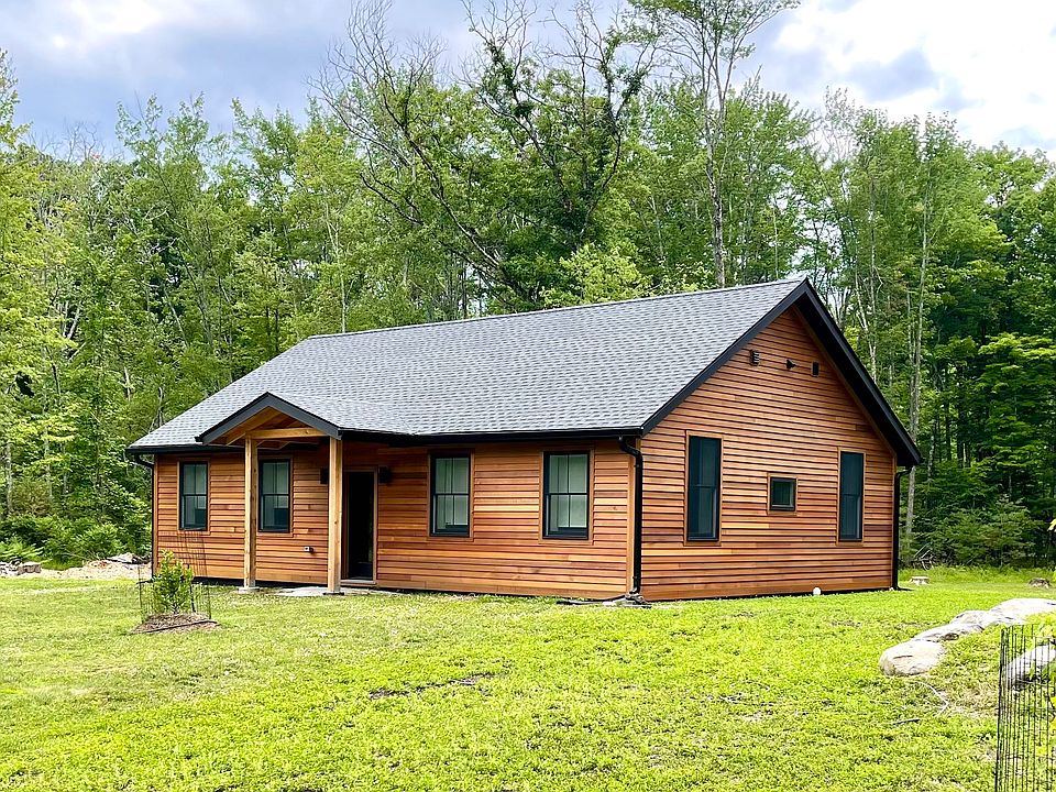 Cedar-clad home with newly planted maple and magnolia trees in front.