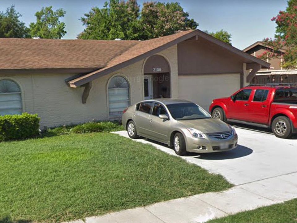 Street-view of the house with large driveway and single-car garage access