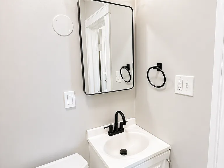 Refreshed bathroom with new fixtures, cabinets, mirror, faucet, hardware, paint.