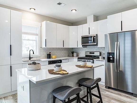 Lots of cabinets in this chef's kitchen with tile backsplash, all new SS gas stove, microwave, dishwasher and refrigerator.