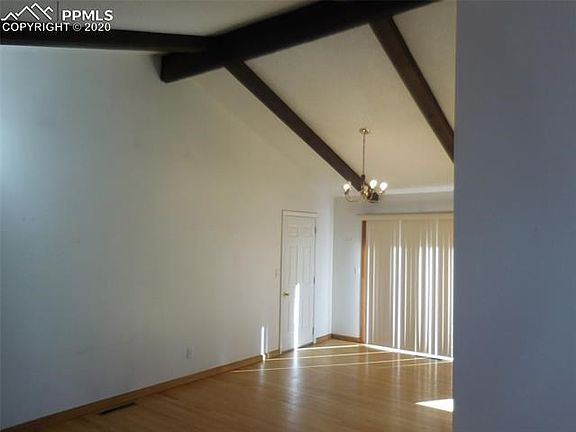 Dining room with vaulted beamed ceiling with walkout to the back deck
