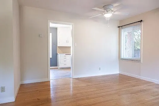 Living room facing towards the dining space and the opening to the kitchen which is located in the back