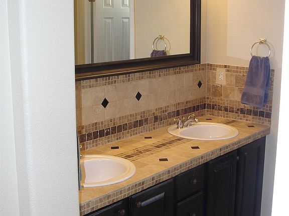 Custom tiled master vanity with double sinks