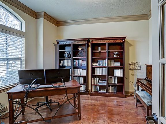 Large study at the front with French doors, wood floors, and crown molding.