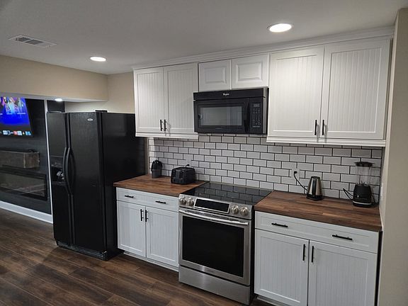 A modern kitchen with all essential appliances - Fridge/Freezer, Electric stove, Microwave and Dishwasher