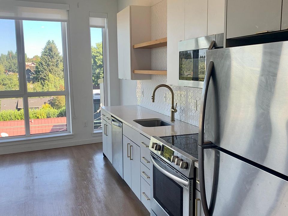 Living room and kitchen. Kitchen includes dishwasher, oven/range, full size refrigerator, microwave, stainless sink.