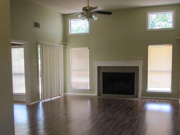 Living Room with wood burning fireplace and high ceiling.