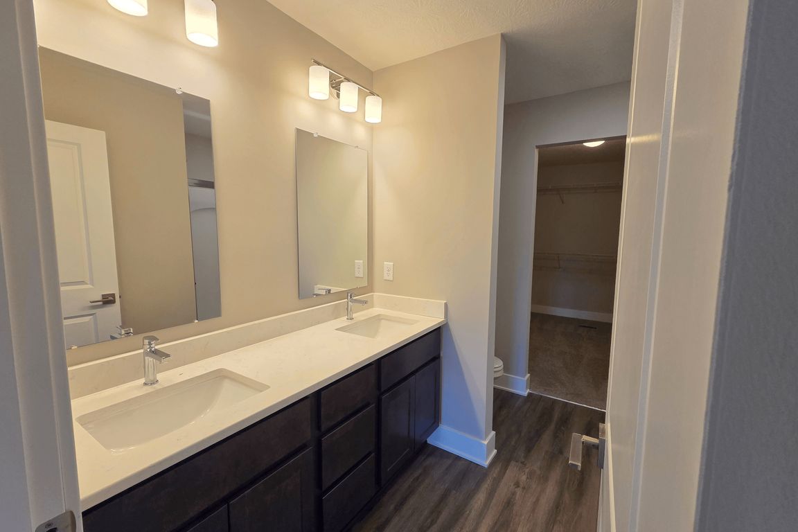 Townhome primary bathroom with dual sinks, shower, and closet.