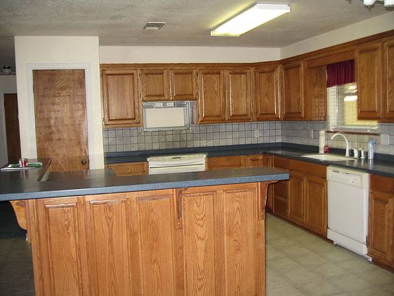 Kitchen has lots of cabinets w/Corian countertops