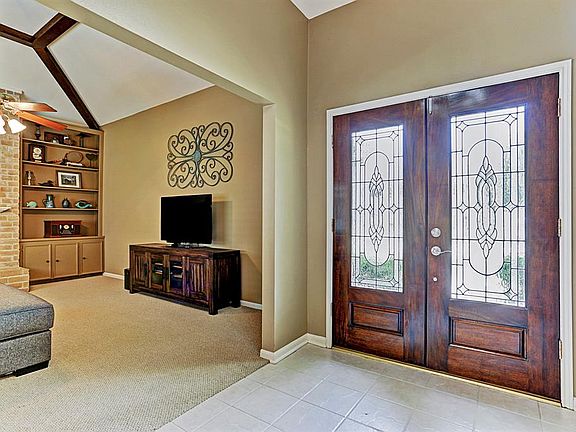 Entry has beautiful double leaded glass doors, tile floor, and high ceiling.