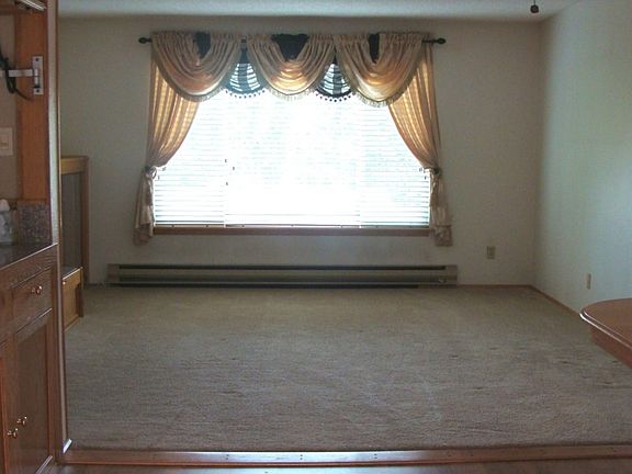 View of the living room from dining room. Living room floor covering is carpet and dining is hardwoo