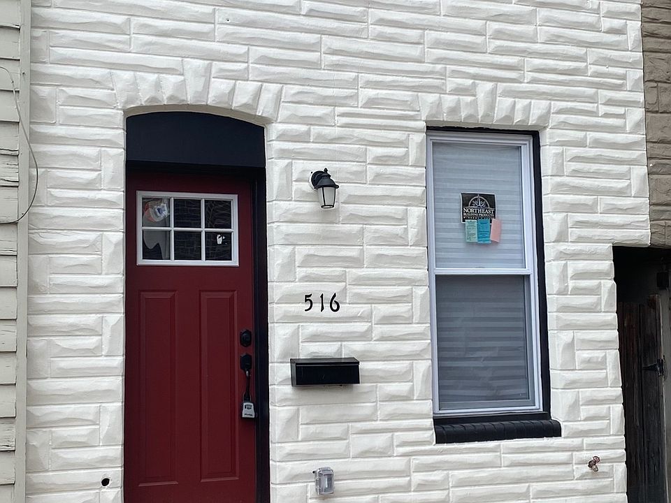 Beautiful white paint and brick exterior with red door on a quiet street