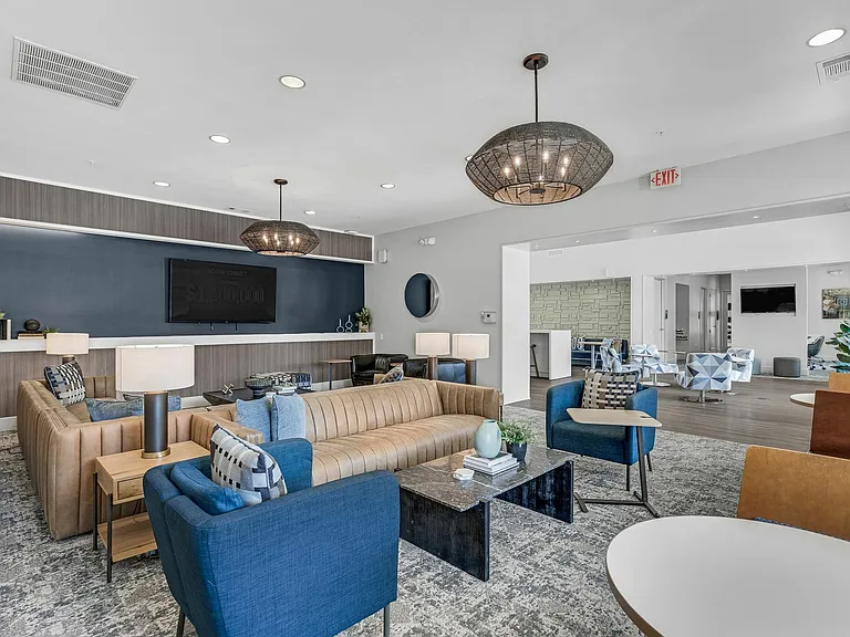 Gather and relax in the modern resident lounge with comfortable seating and a bar area at The Flatts Starkville, perfect for student living near MSU.