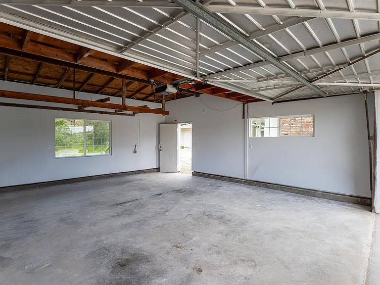 Huge and deep two car garage with new widnows completely insulated and primed. New smart garage door opener installed that works through app or remotes.